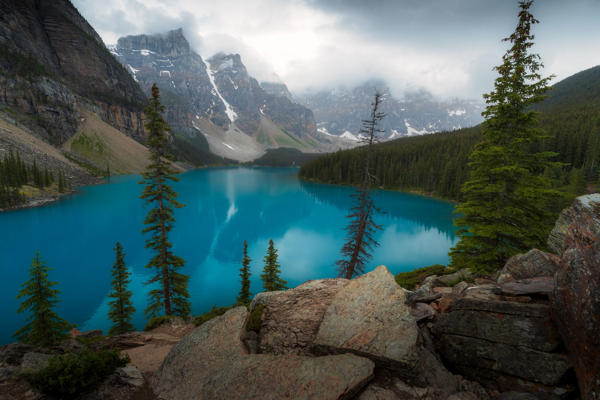 Moraine Lake nebo Peyto Lake z vyhlídky, širší záběr s horami. Titulní fotka článku.