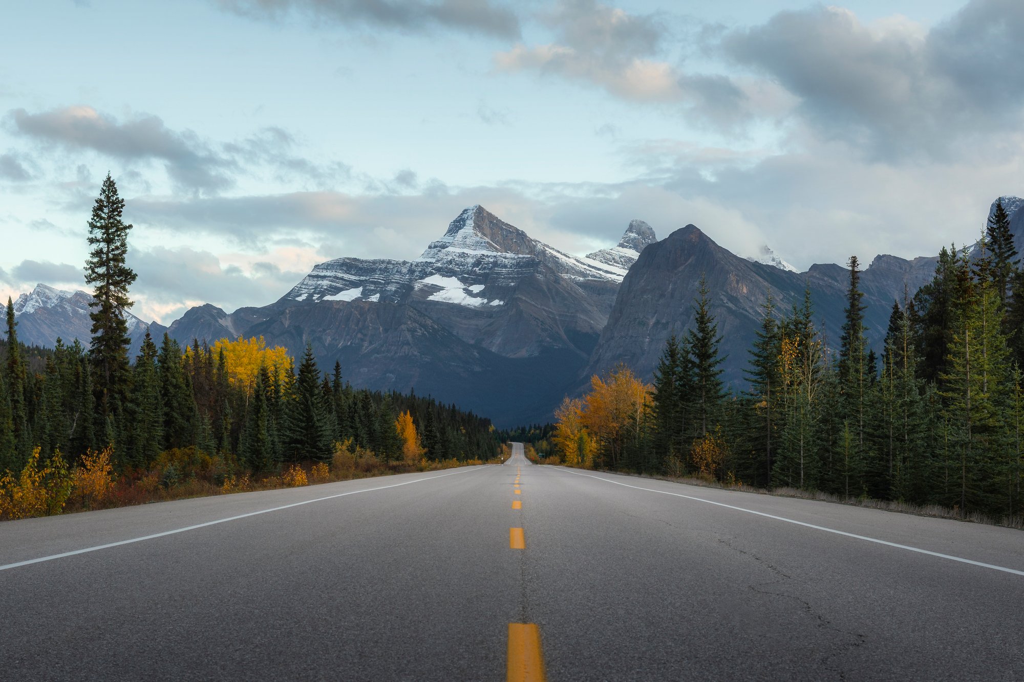 silnice Icefields Parkway mezi horami, ideálně s autem pro měřítko.