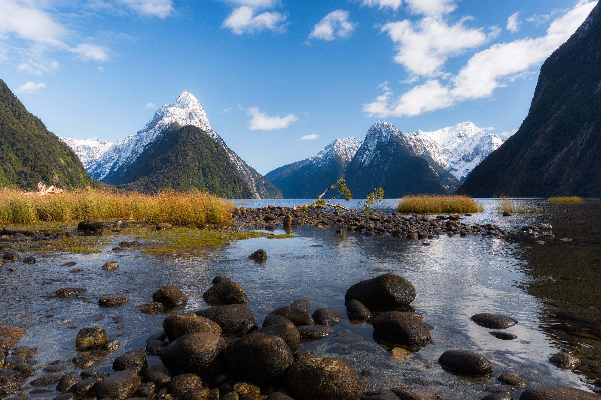 Milford Sound s Mitre Peak, ideálně v dešti nebo po dešti s vodopády na stěnách.